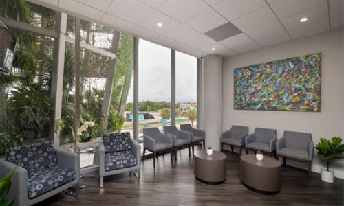 Patient waiting area with large windows, seating and colorful wall art