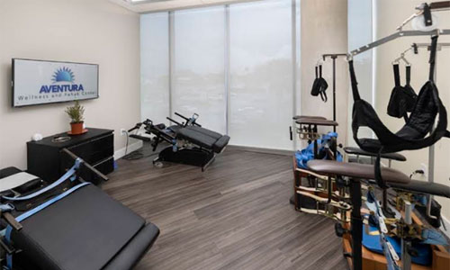 Rehabilitation room with chiropractic tables and suspension therapy equipment