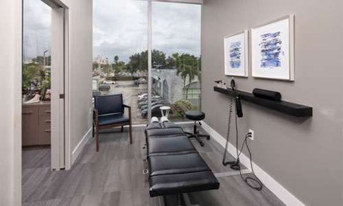 Chiropractic treatment room with adjustment table and waterfront view