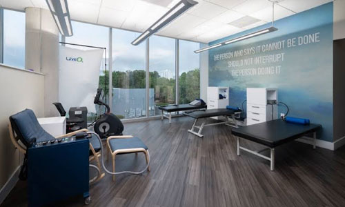 Bright rehabilitation room with treatment tables and exercise equipment